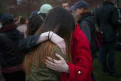 Mourners embrace while taking part in a vigil for bomb victims a day after two explosions hit the Boston Marathon in Boston