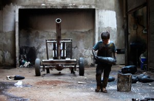 War in Syria Issa carries a mortar shell in a weapons factory of the Free Syrian Army in Aleppo